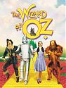 A scarecrow, tin man, young woman, and lion walk down the yellow brick road with a small dog looking at them from the text title of the movie